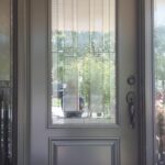 Glass-paneled front door with decorative design.