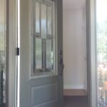 Partially open gray front door.