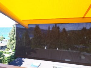 Yellow retractable awning with screen.