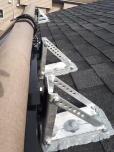 black-and-tan-awning-installed-on-roof-mount-brackets