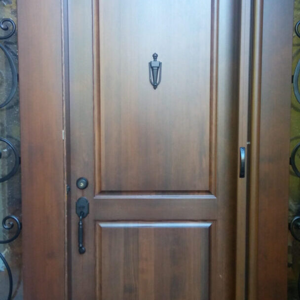 Dark wood door with doorknob and screen.